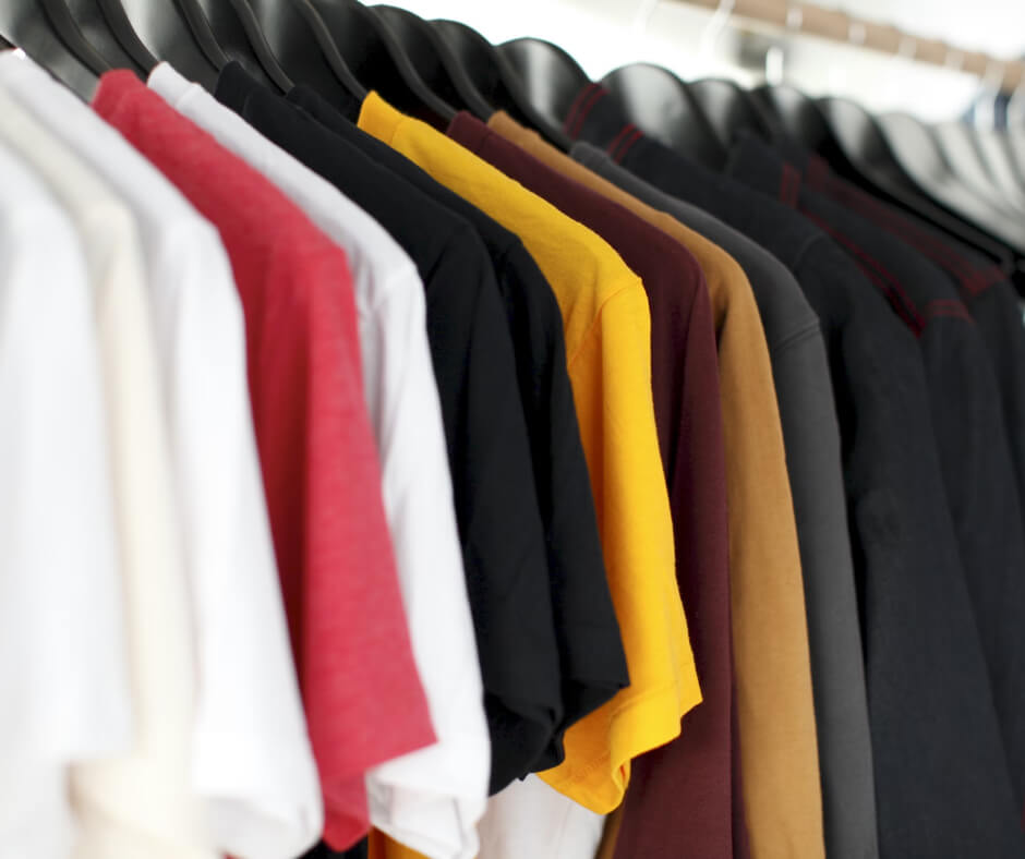 A row of shirts hanging on a rack.