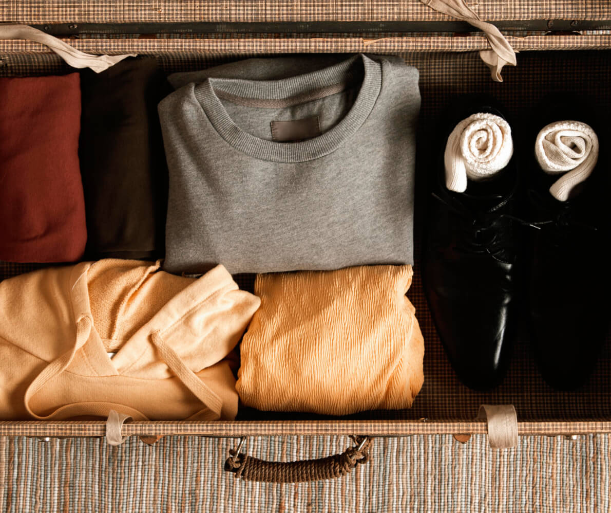 A suitcase filled with clothes and shoes.