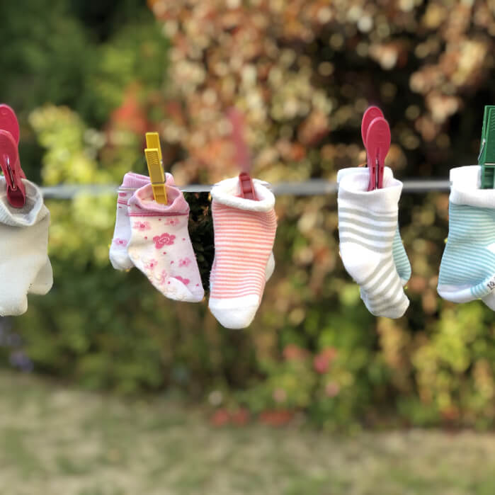 A line of socks hanging on a clothes line.