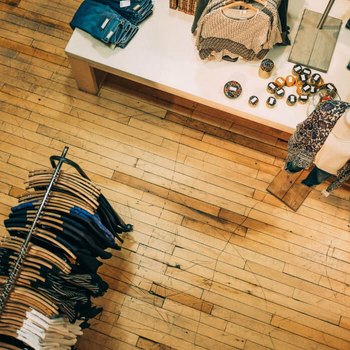 A room filled with lots of clothes on a wooden floor.