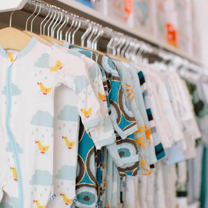A rack of baby clothes hanging on a wall.